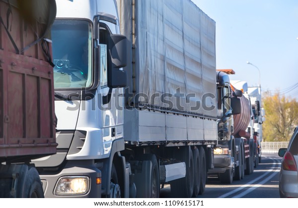trucks in\
traffic jam on the road during the\
day