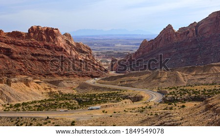 trucks traveling through a pass in the incredible rock formations  of san rafael swell in a very remote part of utah, near green river 