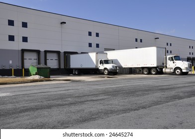 trucks at unloading docks for large warehouse
