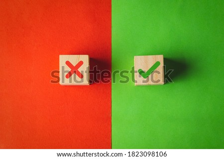 True and false symbols, Yes or No on wood cubes on red and green background.