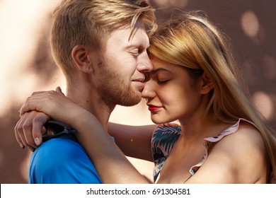 True Genuine Feelings, Love, Romance And Tenderness Concept. Lifestyle Portrait Of Charming Cute Young European Couple Or Family Standing Outdoors, Embracing And Keeping Eyes Closed, Enjoying Moment