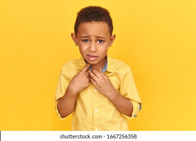 True Human Reactions, Emotions And Feelings. Emotional Frightened Preschool Boy In Jacket Having Scared Look, Pointing Index Finger At Himself, Asking Who Me? Afraid Black Child Being Intimidated