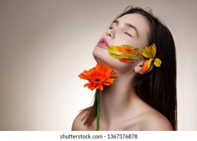 True satisfaction. Dark-haired skinny model getting true satisfaction while posing with flowers