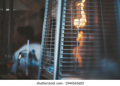 A True Tilt-shift Photo Of A Street Gas Heater For A Patio With A Flame Of Fire Inside, With A Selective Focus On The Part Of A Protective Metal Grid