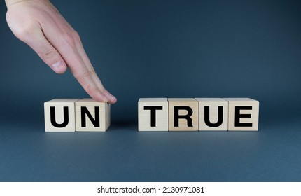 True Or Untrue The Hand Makes The Word Untrue Into True From The Cubes. Media, Information And Business Concept