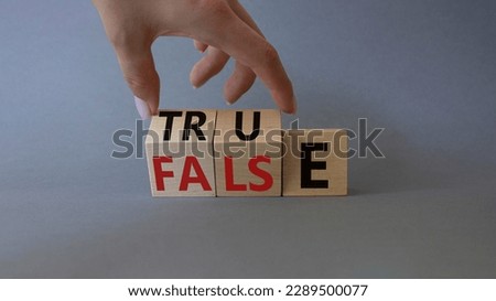 True vs False symbol. Businessman Hand turns cubes and changes word False to True. Beautiful grey background. Business and True vs False concept. Copy space