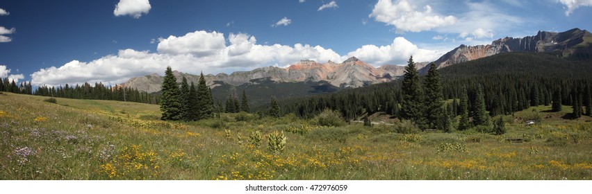 True wide panorama of the San Juan mountain range of southwest Colorado, centered on Vermillion Peak, in the summertime, with a field of wildflowers in the foreground