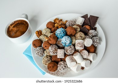 truffles with cocoa, coconut and sesame with chocolate and marshmallows and a cup of aromatic coffee, delicious dessert