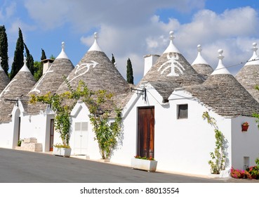 Trulli houses with painted symbols on the conical roofs in Alberobello, Italy, Puglia