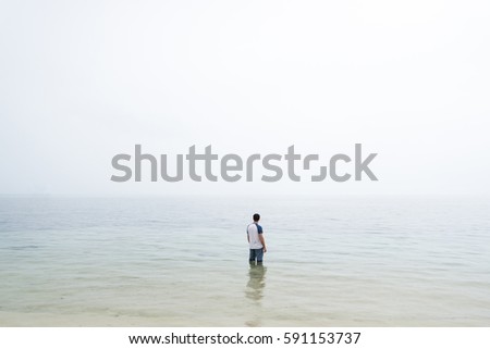 Similar – a woman looks at the sea. rear view, blurred