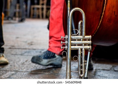 Trumpet On A Ground .artists Street Busker Performing Jazz Songs Outdoors. Close Up Of Big Tube