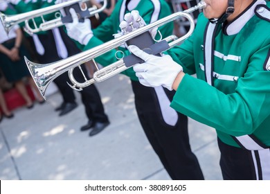 trumpet player in green shirt blowing in marching band
