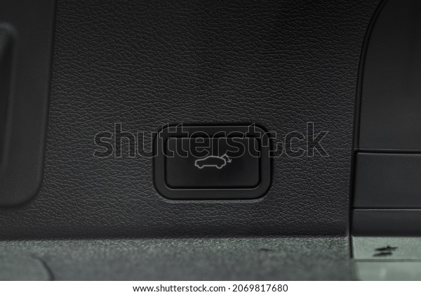 Trunk electric close and lock\
button close up view. Vehicle interior detail of a modern\
car.