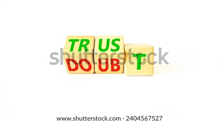 Trust or doubt symbol. Turned wooden cubes and changed the word doubt to trust or vice versa. Beautiful white table, white background, copy space. Business and trust or doubt concept.