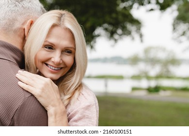 Trust And Love Concept. Caucasian Mature Heterosexual Couple Hugging Embracing Together While Walking On Romantic Date In Park Forest Outdoors.