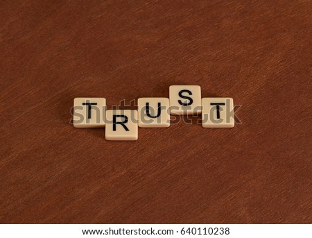 Trust sign. Loyalty concept. Ivory tiles with capital letters on mahogany board.