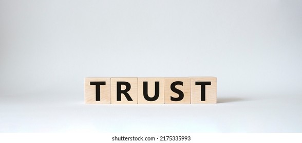 Trust Symbol. Concept Word Trust On Wooden Cubes. Beautiful White Background. Business And Trust Concept. Copy Space.
