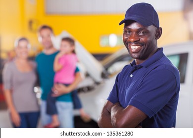 trustworthy african auto mechanic standing in front of family inside garage