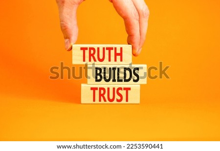 Truth builds trust symbol. Concept words Truth builds trust on wooden blocks on a beautiful orange table orange background. Businessman hand. Business truth builds trust concept. Copy space.