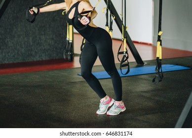 TRX Concept. Beautiful Lady Exercising Her Muscles. Athletic Shirtless Female Doing Workouts On A Back With Power Exercise Machine In A Gym Club. Sexy Body