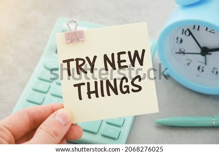 TRY NEW THINGS, message on the card shown by a man , vintage tone