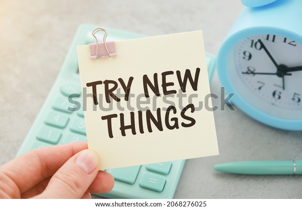 TRY NEW THINGS, message on the card shown by a man ,\
vintage tone