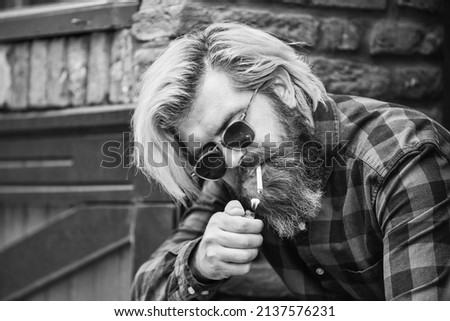 Try to quit smoking. hipster lifestyle. man smoking a cigarette. business man in glasses smoking cigarette on street. go out for smoke break. Handsome stylish man smoking outside in urban setting