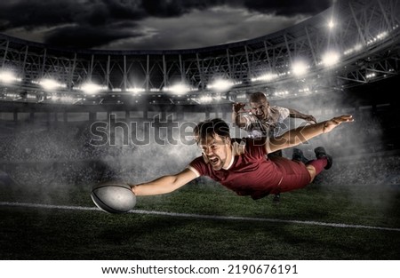 Try. Rugby football player in action on dark arena background