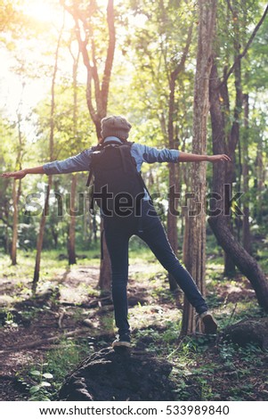 Similar – Hiker woman with backpack raising her arms into the forest