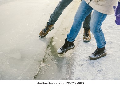 Trying The Danger Of The Foot, Testing The Thin Ice Near The Shore. A Pair Of Lovers Walk With A Walk Along A Frozen Lake To Press Foot On The Ice.