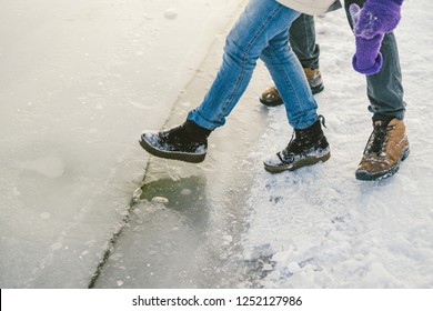 Trying The Danger Of The Foot, Testing The Thin Ice Near The Shore. A Pair Of Lovers Walk With A Walk Along A Frozen Lake To Press Foot On The Ice.