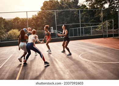 Trying to get through. Cropped shot of a diverse group of sportswomen playing a competitive game of basketball together during the day. - Powered by Shutterstock