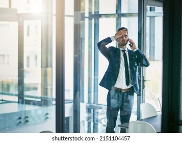Trying hard to keep his composure. Shot of a young businessman losing his temper while talking on his cellphone.