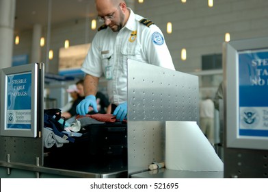 A TSA Agent Searches Luggage At An Airport. (12MP Camera, NO Model Release, Editorial Only)