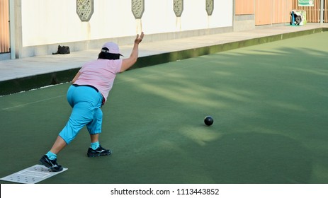 Tseung Kwan O, Kowloon, Hong Kong - 5 April 2018: A lady play turf bowling in an artificial turf bowling green inside a town park.