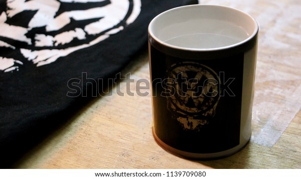 T-shirt and a cup with a Volkswagen logo on a
wooden background
