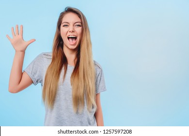 T-shirt gray blue background jeans girl raised her hand shows an open palm five fingers. Concept ok accord peace reciprocity, joy. Copy space right. Closeup. - Shutterstock ID 1257597208