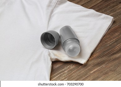 T-shirt With Sweat Stain And Deodorant For Man On Wooden Background