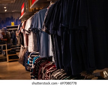 t-shirts in different colors on hangers in a retail shop - Shutterstock ID 697080778