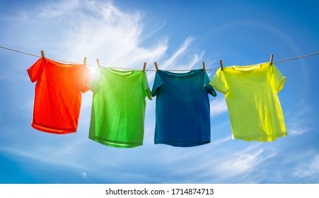 T-shirts hanging on a clothesline in front of blue sky and sun - Powered by Shutterstock