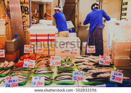 Tsukiji, Tokyo, Japan - October 24, 2016 : Japanese fishmonger preparing and packing fish into foam box at Tsukiji Fish Market in Tokyo, Japan. film style photo