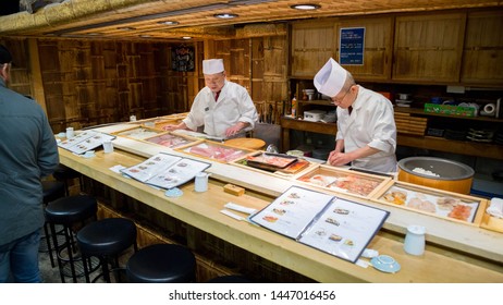 Tsukiji, Tokyo/japan - 11 28 2019: 2 Sushi Chefs At Work In Small Japanese Sushi Bar In Tsukiji Fish Market.