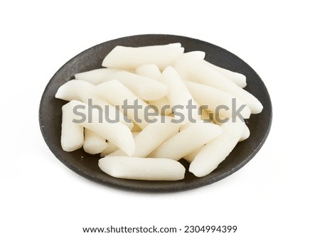 Tteok or Korean Rice Cakes in plate isolated on white background. pile of Tteok or Korean Rice Cakes in dish isolated on white background. Tteok Korean Rice Cakes                      