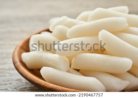 Tteok or Korean Rice Cakes in a wooden plate on wood table background                                                                                  