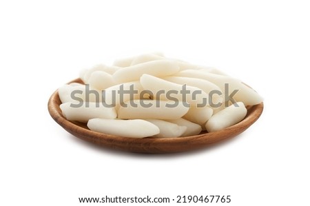 Tteok or Korean Rice Cakes in wooden plate isolated on white background. pile of Tteok or Korean Rice Cakes in wooden dish isolated on white background