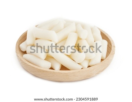 Tteok or Korean Rice Cakes in wooden plate isolated on white background. pile of Tteok or Korean Rice Cakes in wooden dish isolated on white background. Tteok Korean Rice Cakes                      