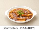 Tteokbokki or Topokki , stir fried rice cake stick, popular Korean street food with spicy gochujang sauce and sesame seed. 
