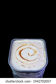 Tub of Delicious Salted Caramel Macadamia Nut Ice Cream Isolated on Black Background