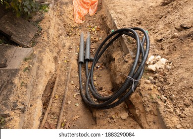 Tube and cables. Building of lines of communication optical network connection. Laying underground tow cable. Excavation of trench by hand excavator and installation.