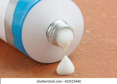 A tube of generic ointment or cream with a droplet squeezed out